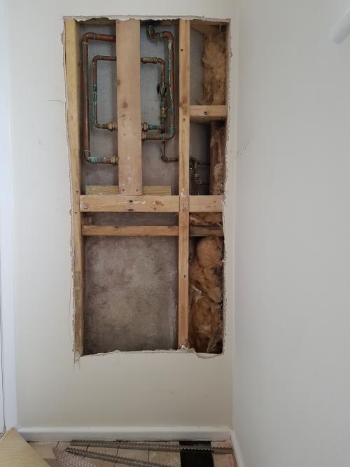 Landing partition wall cut out to expose pipework